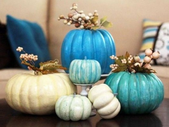 an arrangement of neutral and bright blue pumpkins, berries and little flowers for a centerpiece or decoration