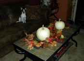 a coffee table with bright fall leaves, berries and white pumpkins here and there is classics
