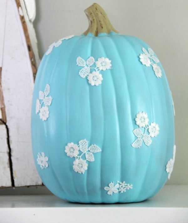 a blue pumpkin with white lace flowers attached looks super cute and fun, such a color will make a statement
