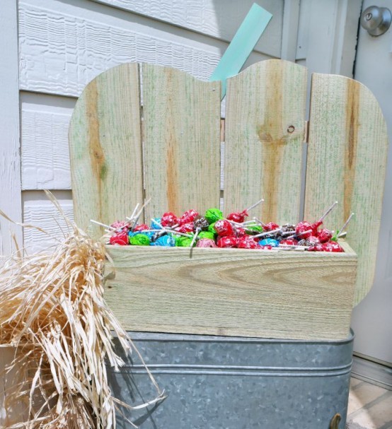 a neutral pumpkin-shaped stand with candies is a gorgeous solution for indoors and outdoors