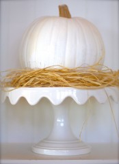a white pumpkins with hay on a white refined stand for a rustic vintage look in neutrals