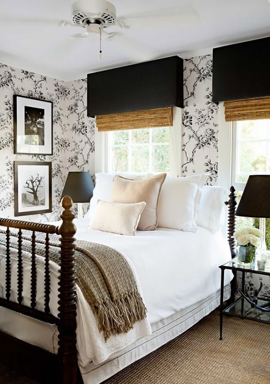 a chic farmhouse bedroom done in black, white and neutrals, with wooden shades and a wooden bed 