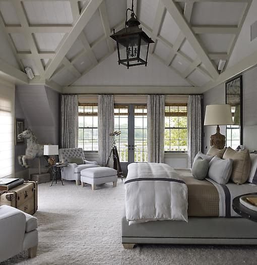 all-white and off-white farmhouse bedroom with neutral upholstered furniture, simple textiles and lamps