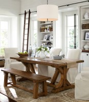a neutral modern farmhouse dining room with a wooden dining set, some white chairs and built-in storage units