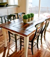 a small and simple dining space with a wood clad dining table, wooden chairs and boxwood planters