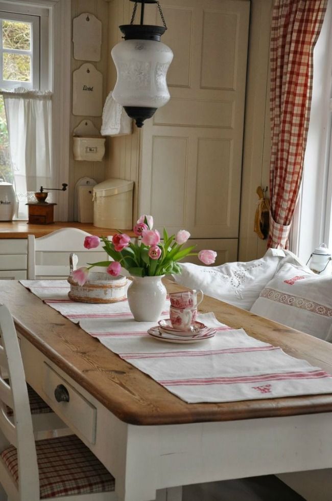 a traditional farmhouse dining area with white wood, a dining set and checked textiles