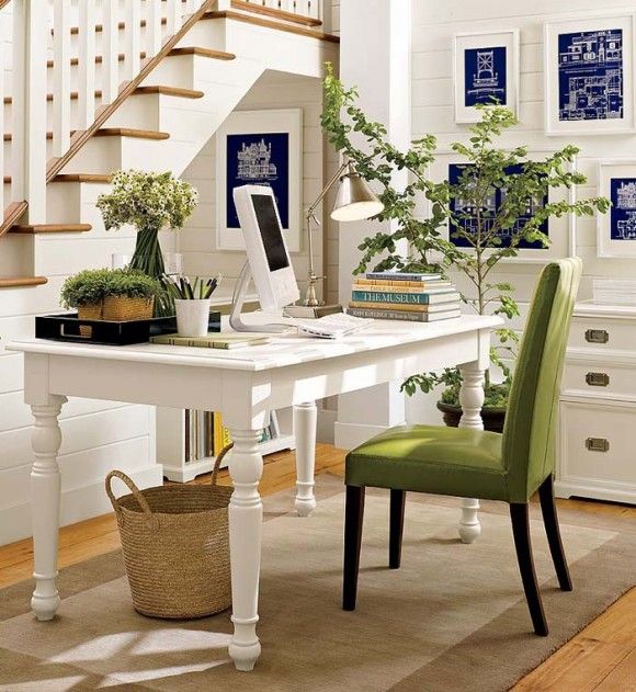 a pretty and light filled modern farmhouse home office in white, with beadboard on the walls, a vintage desk and a green chair and some greenery to refresh the space visually