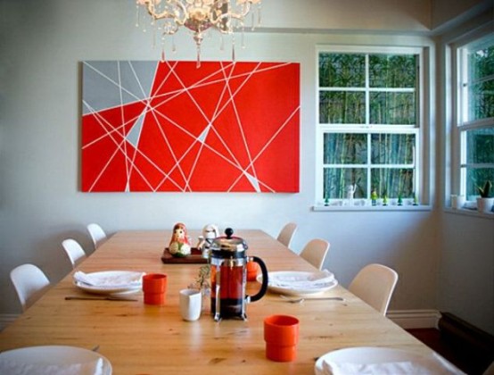 a modern dining room with a statement grey and red geometric artwork, a stained table and white chairs is a lovely and stylish space