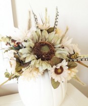 an elegant fall centerpiece of a white pumpkin, faux blooms, foliage and dried touches is a stylish centerpiece idea