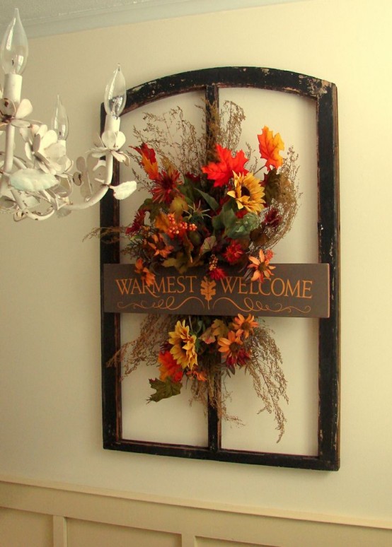 a vintage-inspired faux flower decoration with twigs, grasses and leaves in a frame and with a sign
