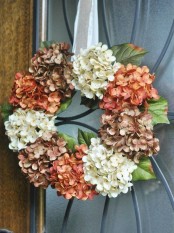 a vintage-inspired faux hydrangea wreath in brown, rust and white on a silk ribbon is a veyr stylish idea for decor