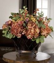 a vintage urn with faux greenery and dried blooms is a refined and chic centerpiece for the fall