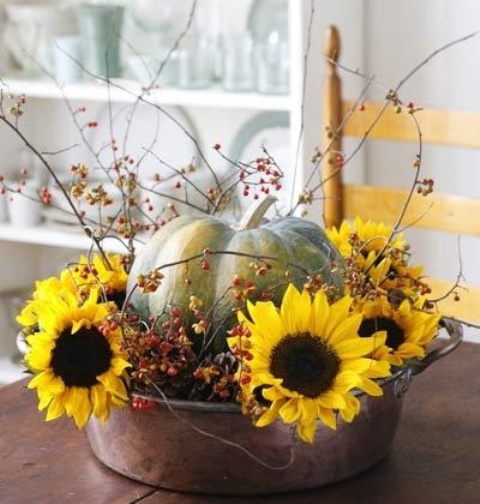 a metal bathtub with branches with berries, faux sunflowers and a faux pumpkin painted with chalk paint