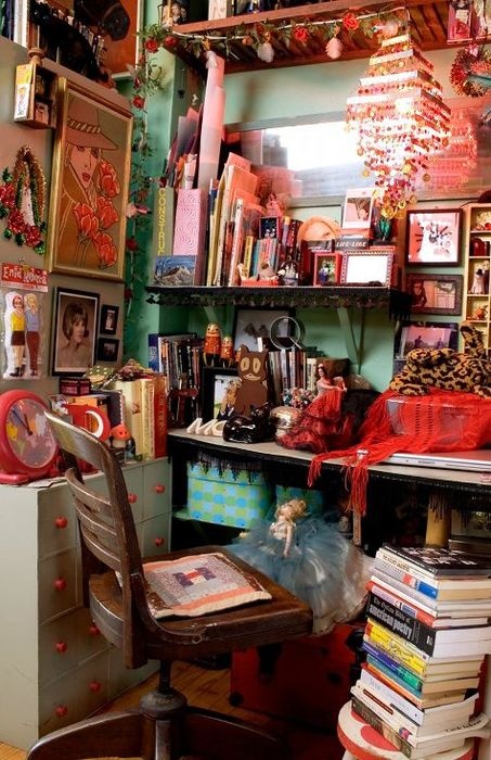 a colorful and fun boho home office in green and red, bold artworks and books, a vintage desk and chair and lots of mess