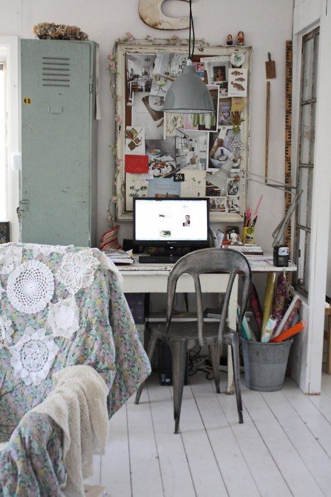 a boho chic and shabby home office with white walls and floor, a green storage unit, a memo board with various photos and ideas, a metal chair