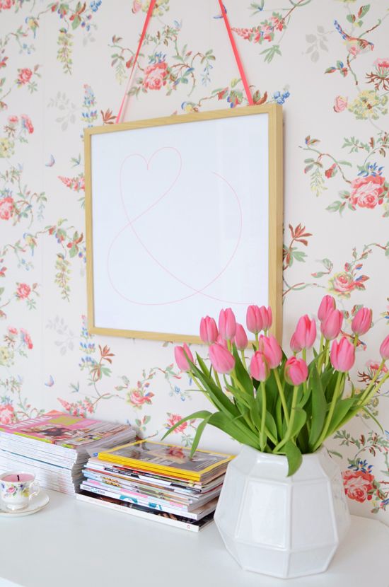 floral wallpaper and pink tulips in a vase bring a spring or summer feel to the space and make it cooler and brighter