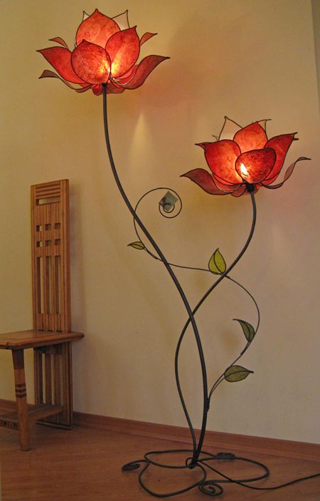 a large floor lamp with several red flower lampshades and leaves looks very quirky and elegant at the same time