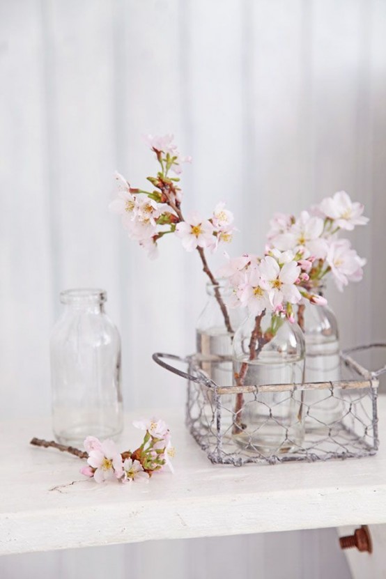 a wire basket with bottles and blush cherry blossom is a lovely rustic and shabby chic arrangement for spring