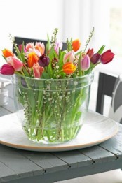 a large jar with colorful tulips and willow is a gorgeous centerpiece for spring with a modern and simple feel