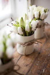 white terracotta vases with white tulips and dark branches plus twine braided bows is a cool idea to refresh your space for spring