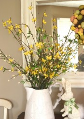 a vintage jar with yellow blooming branches, willow is a pretty vintage and rustic decoration or centerpiece