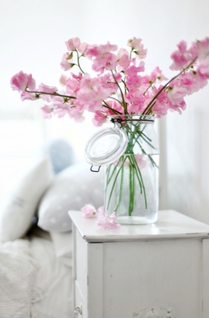 a clear vase with pink cherry blossom is a beautiful idea for adding a spring touch to the space and some color, too
