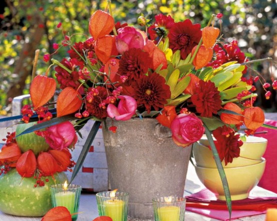a bold fall or Thanksgiving centerpiece of a bucket, bold red, pink and burgundy blooms, berries, dried blooms and foliage is amazing and brings much color