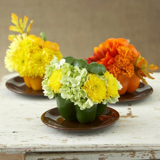 super bright mini Thanksgiving centerpieces made of bold peppers filled with blooms  that match in color look fun and super cool