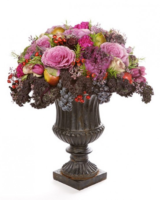 a super lush and bold Thanksgiving centerpiece of a vintage urn, purple and pink blooms, veggies, grapes and dark foliage is a bold statement for a vintage space