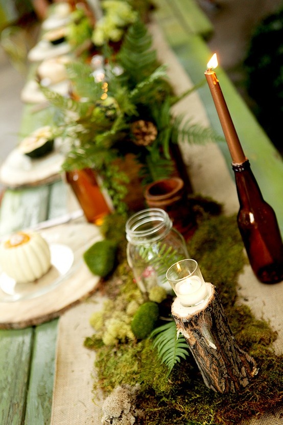 a green table, green leaves, moss, fern leaves and moss balls for a woodland-like Thanksgiving tablescape