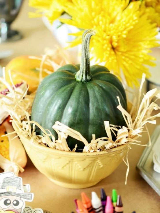 a green pumpkin with husks, bold yellow blooms for adding color to your Thanksgiving tablescape