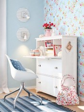 a blue and red floral print wall, some fresh blooms and a blue printed pillow for a fresh spring feel in the space