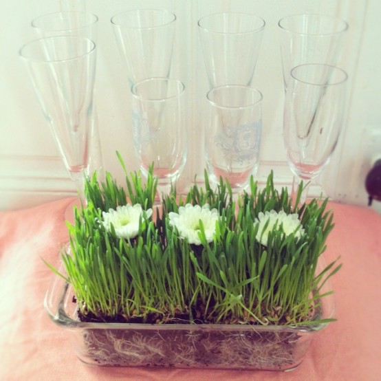 a sheer bowl with wheatgrass and white blooms is a stylish spring decor idea
