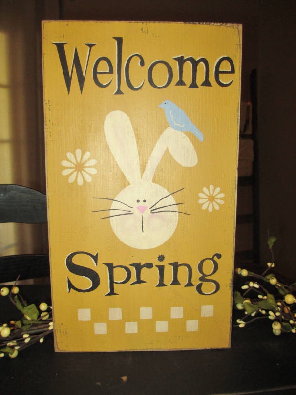 a sunny yellow sign with black letters and a bunny, with a bird and bright blooms is a lovely idea