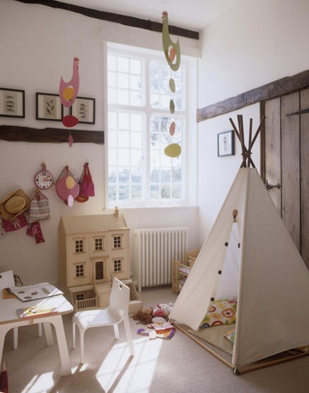 a neutral and whimsical kid's space with a teepee, a dollhouse and a studying and drawing space, some pretty decor and artwork