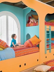 a colorful shared kid’s room with an orange and blue bunk bed and colorful bedding, bright printed pillows feels a bit Moroccan