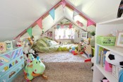 afun and colorful attic kid’s room with a large green bed, colorful buntings, a blue dresser and a storage unit with colorful decor