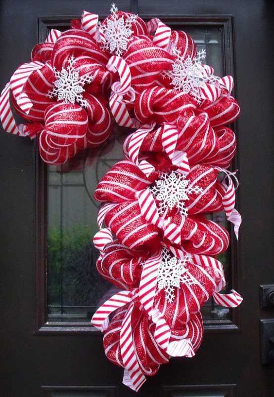 a red and white candy cane shaped wreath made of ribbons and snowflakes is a very creative and cool decoration for Christmas