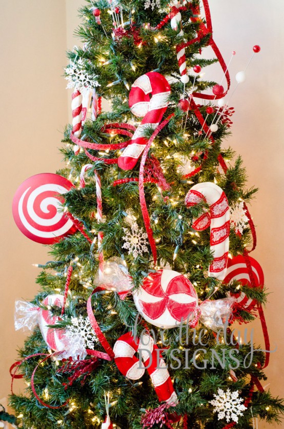 bright Christmas tree decor with red ribbons and oversized red and white fabric peppermints and candy canes looks fun and bold