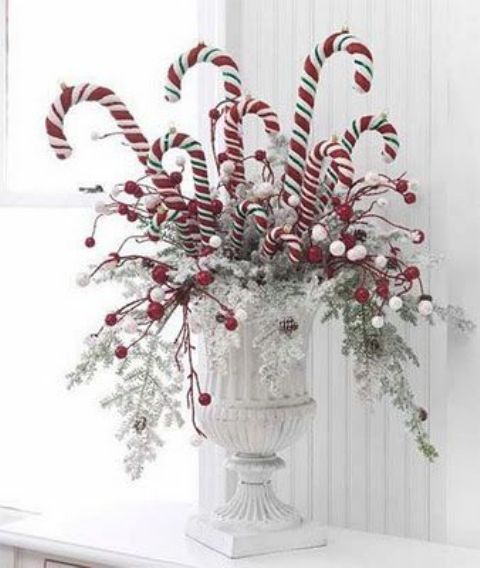 a bold Christmas arrangement in a vintage urn, oversized faux candy canes and snowy and frozen branches is a lovely idea