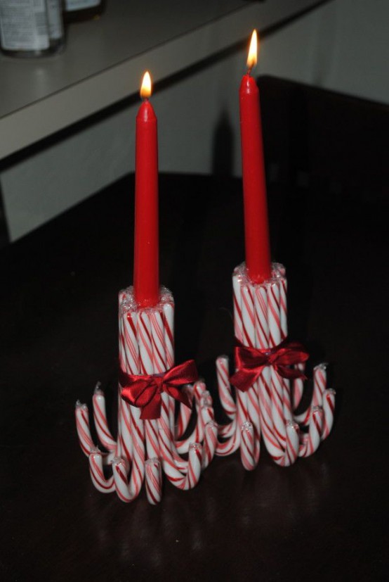 red candles placed into candleholders made of candy canes are great for Christmas decor and you can DIY that