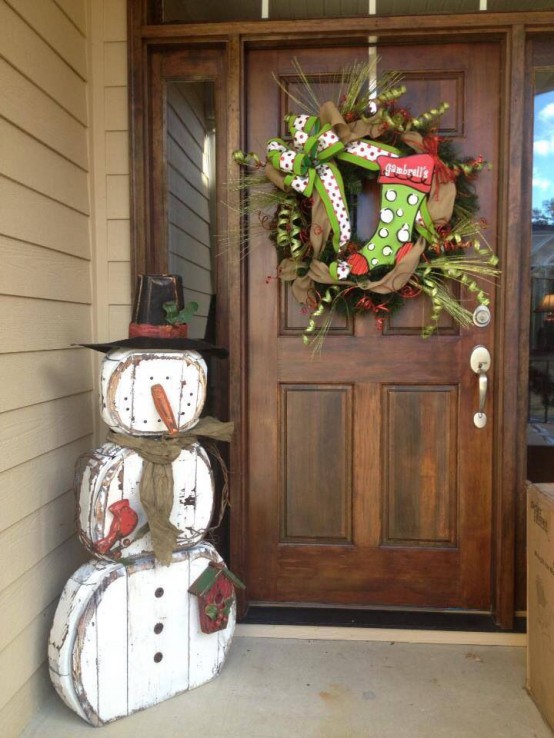 a shabby chic snowman decoration with a hat, a burlap scarf and a small bird house is a pretty vintage decoration for outdoors