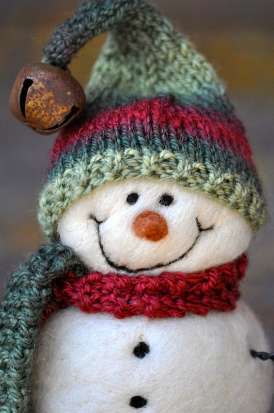 a white felt snowman in a red scarf, a green and red hat with a jingle bell is a very cute Christmas ornament you can make yourself