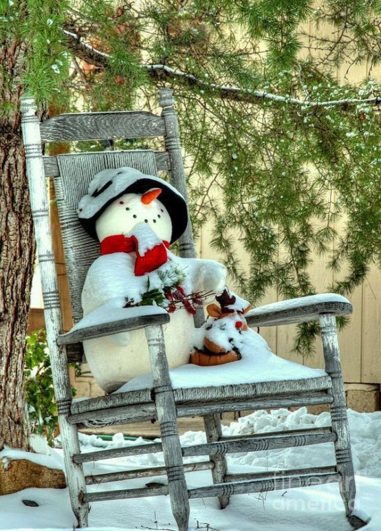 a rocker chair with a felt snowman in a bucket hat and a red scarf, branches and evergreens is a pretty vintage outdoor decor for Christmas