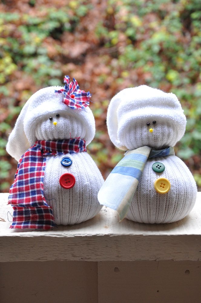 white snowmen of white stockings with colorful buttons and plaid scarves and hats are a cool and very easy Christmas craft