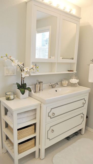 a modenr white mirror featuring a storage space inside and a small open shelf is a cool and smart idea for a modern or modern farmhouse bathroom