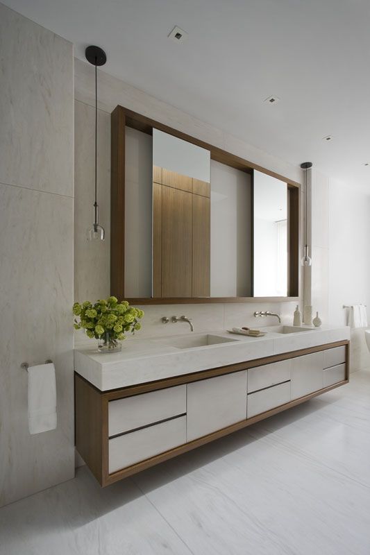a large mirror in a stained frame that features sliding mirrors that hide some stored pieces is a lovely idea for a modern bathroom