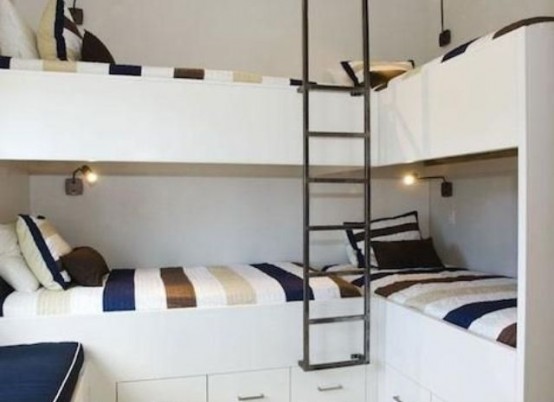 a set of four bunk beds with small wall sconces and a single ladder, no separations between the beds