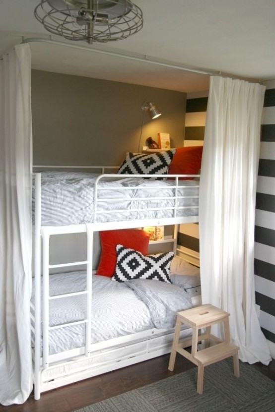a white metal bunk bed unit for two, wall lamps and shelves plus curtains for cozy sleeping