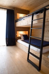 a wood clad bunk bed setup with built-in lights and wiht a metal ladder looks veyr contemporary and inviting